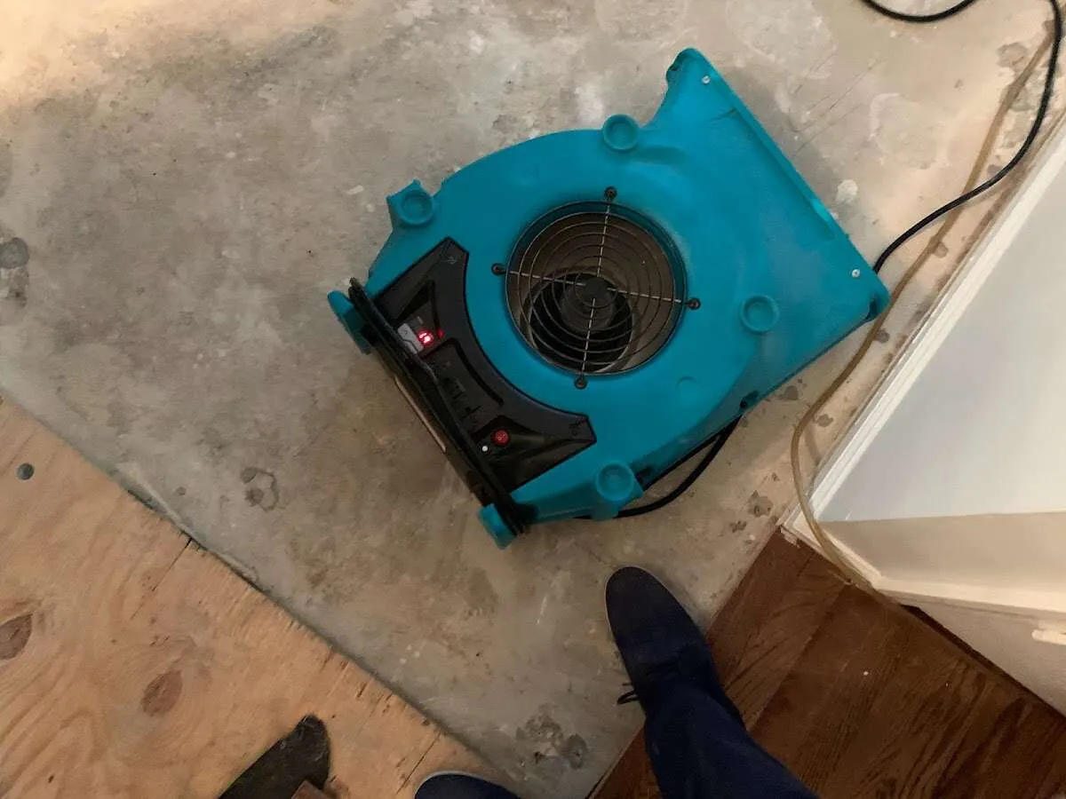 Air mover drying subfloor during Commercial Water Damage Restoration in Vinita